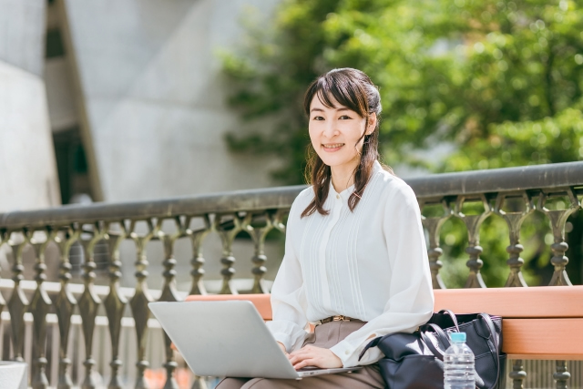 公園でパソコン作業をする女性