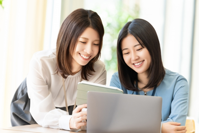 パソコンで情報を検索する女性たち