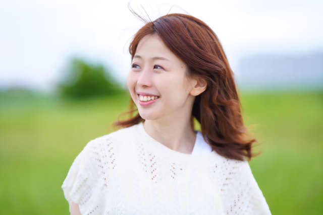 草原でほほ笑む女性